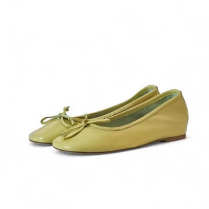 Yellow-green ballet flats with tied bows, low heel, on a white background — casual women's shoes.