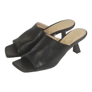 Black open-toe mule sandals with a square toe and a mid-height block heel on a light background, in leather look.