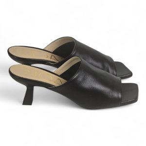 Black leather open-toe heeled mules with a square toe and low block heel on a white background.
