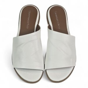 Pair of white open-toe slide sandals viewed from above with wide straps and brown footbeds.