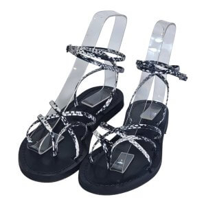 Black platform sandals with clear ankle straps and marbled wraparound straps across the foot.